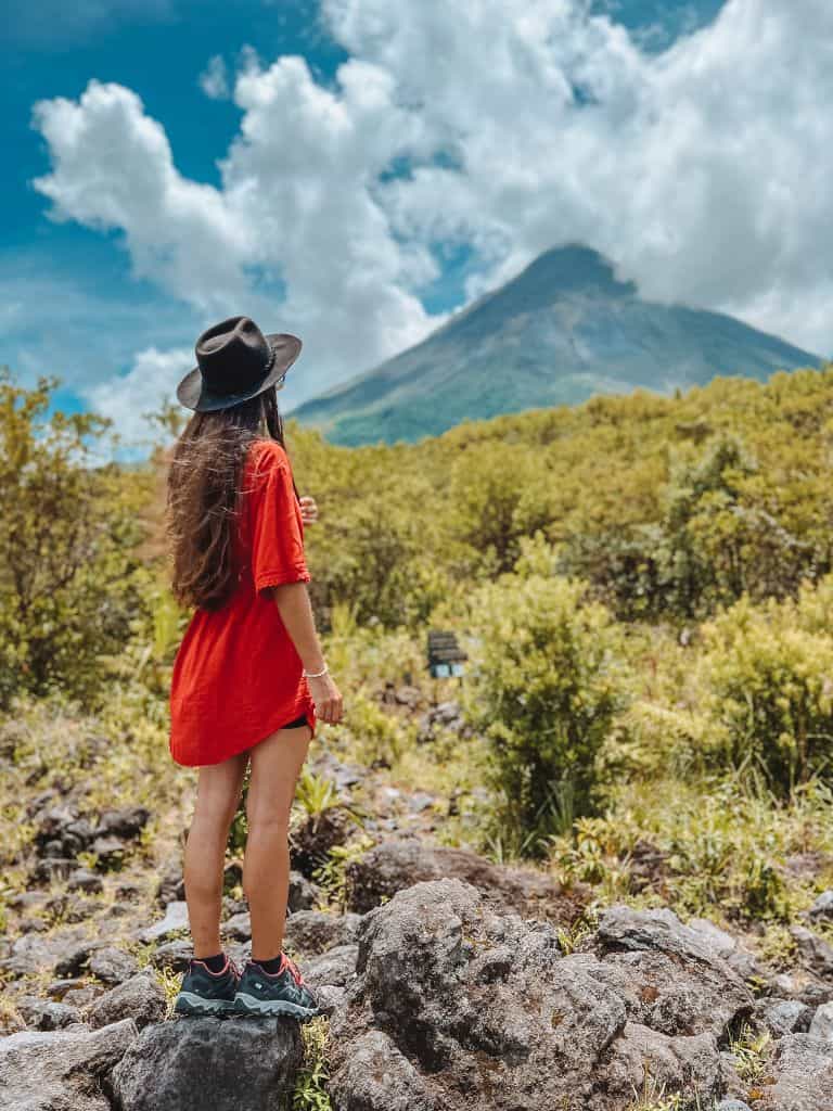 Hikers on Arenal trail with volcano in the background, Costa Rica 2024