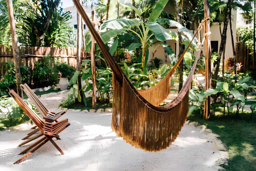 NEST Tulum is a Boutique Hotel with gorgeous beach front views, hammocks, palms trees and coast, beach bed huts and sun beds in Tulum, Riviera Maya, Mexico.