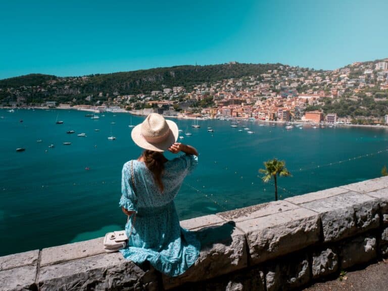 Pristine Mediterranean shoreline with palm-lined promenade and pastel architecture along the glamorous Côte d'Azur